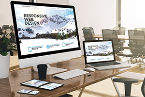 Website design services on monitor and laptop displays in office